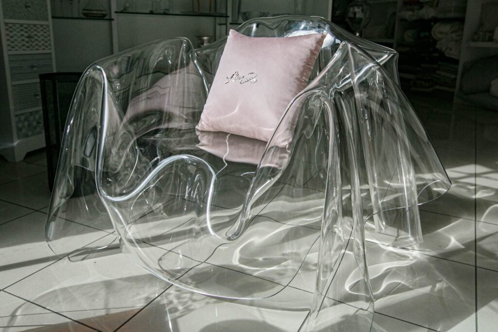 Poltrona trasparente con cuscino rosa tra i complementi d'arredo