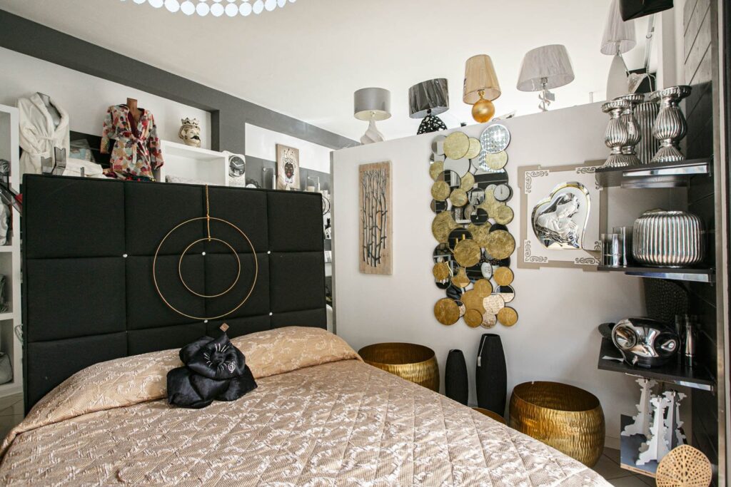 Letto matrimoniale allestito con copriletto e lampade